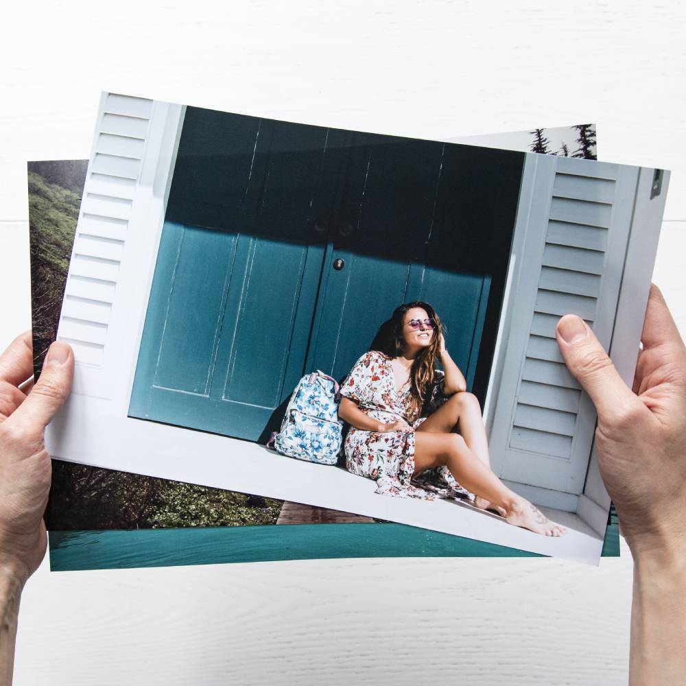 Klasyczne fotografie Fujifilm trzymane w rękach.