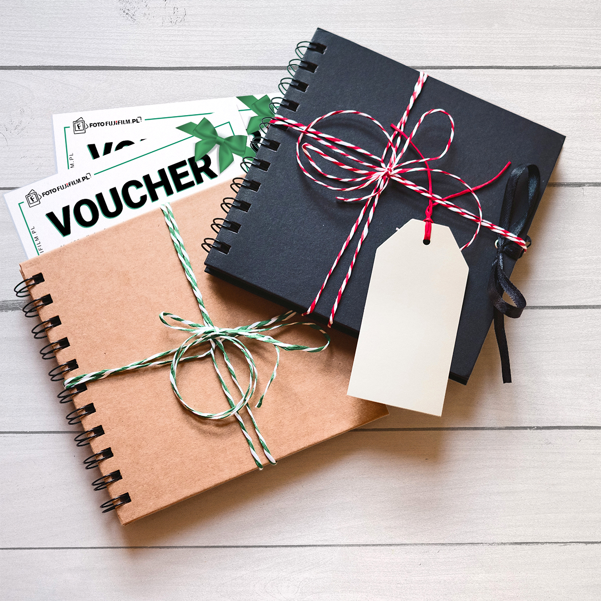 Zdjęcie prezentuje album mini w dwóch kolorystykach z widocznymi voucherami do zamówienia zdjęć. Albumy są przewiązane ozdobnie sznurkiem dwukolorowym.
